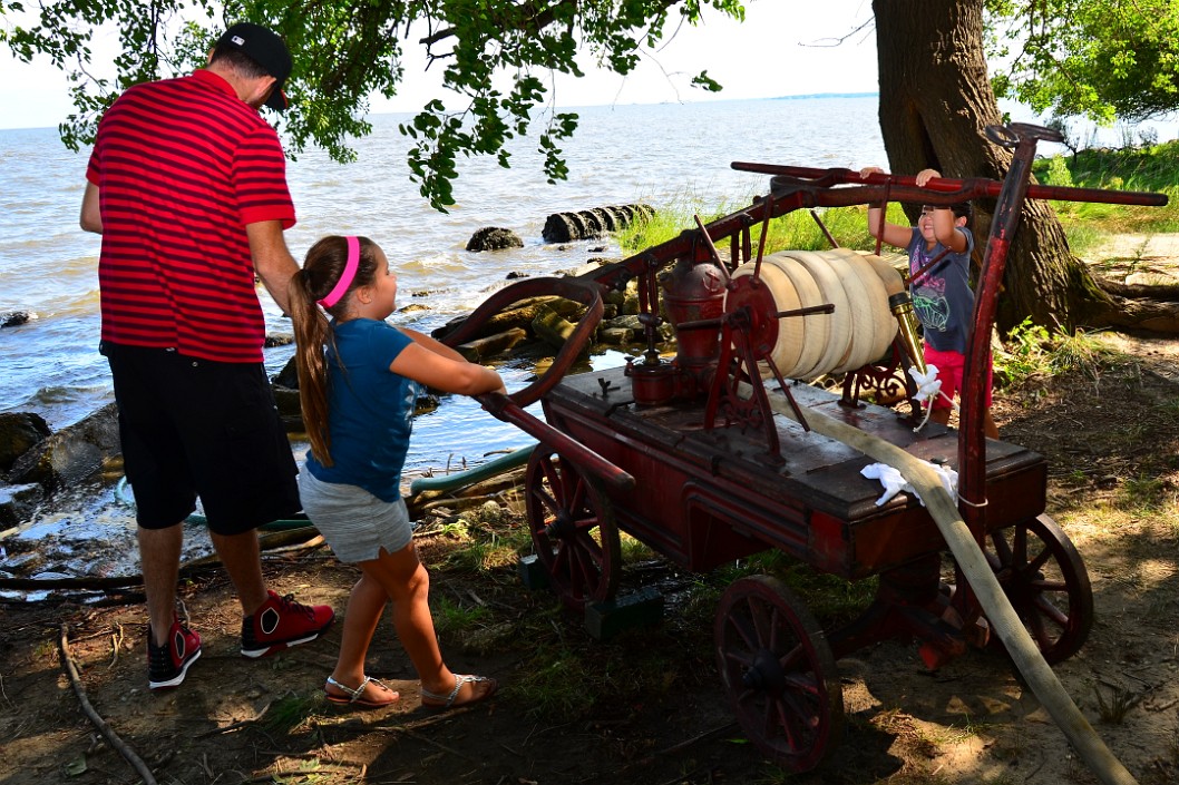 Two Kids at the 19th Century Fire Fighting Pump Two Kids at the 19th Century Fire Fighting Pump