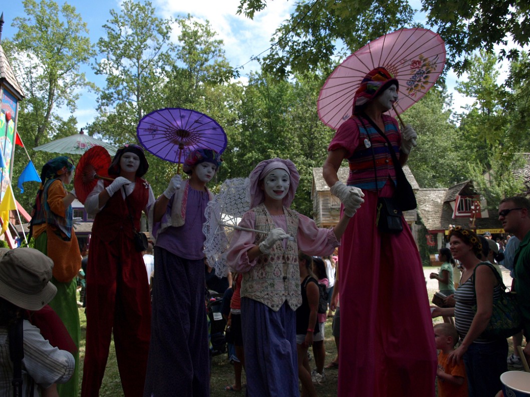 Colorful Stilt Walkers Strolling Through Colorful Stilt Walkers Strolling Through